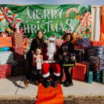 A group of people posing for a picture with santa claus.