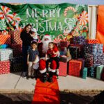 A group of people posing for a picture with santa clause.