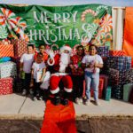 A group of people posing for a picture with santa clause.