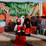 A person in santa claus costume sitting on the ground.