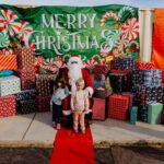 A child and an adult posing with santa claus.