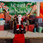 A group of kids sitting around santa clause.