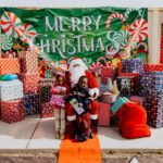 A man in santa claus costume sitting on the ground.