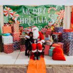 A man in santa claus costume sitting on the ground.