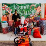 A man and child posing with santa claus.