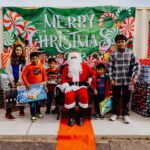 A group of kids standing around santa claus.