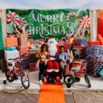 A group of children sitting around santa clause.