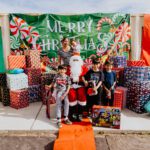 A group of kids standing around santa clause.