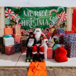 A child sitting on santa 's lap next to a pile of presents.