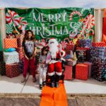 A group of kids standing around santa clause.