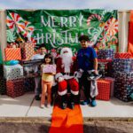 A man and two children posing for a picture with santa.