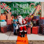 A man in santa claus costume sitting on the ground.