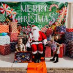 A group of kids sitting around santa clause.