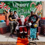 A group of people standing around santa claus.