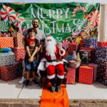 A man and woman posing with santa clause.