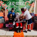 A man sitting in a chair with santa claus.