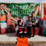 A woman and child posing with santa clause.